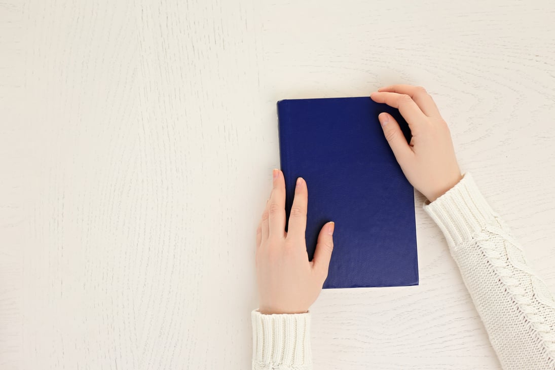 Woman Holding a Blue Notebook